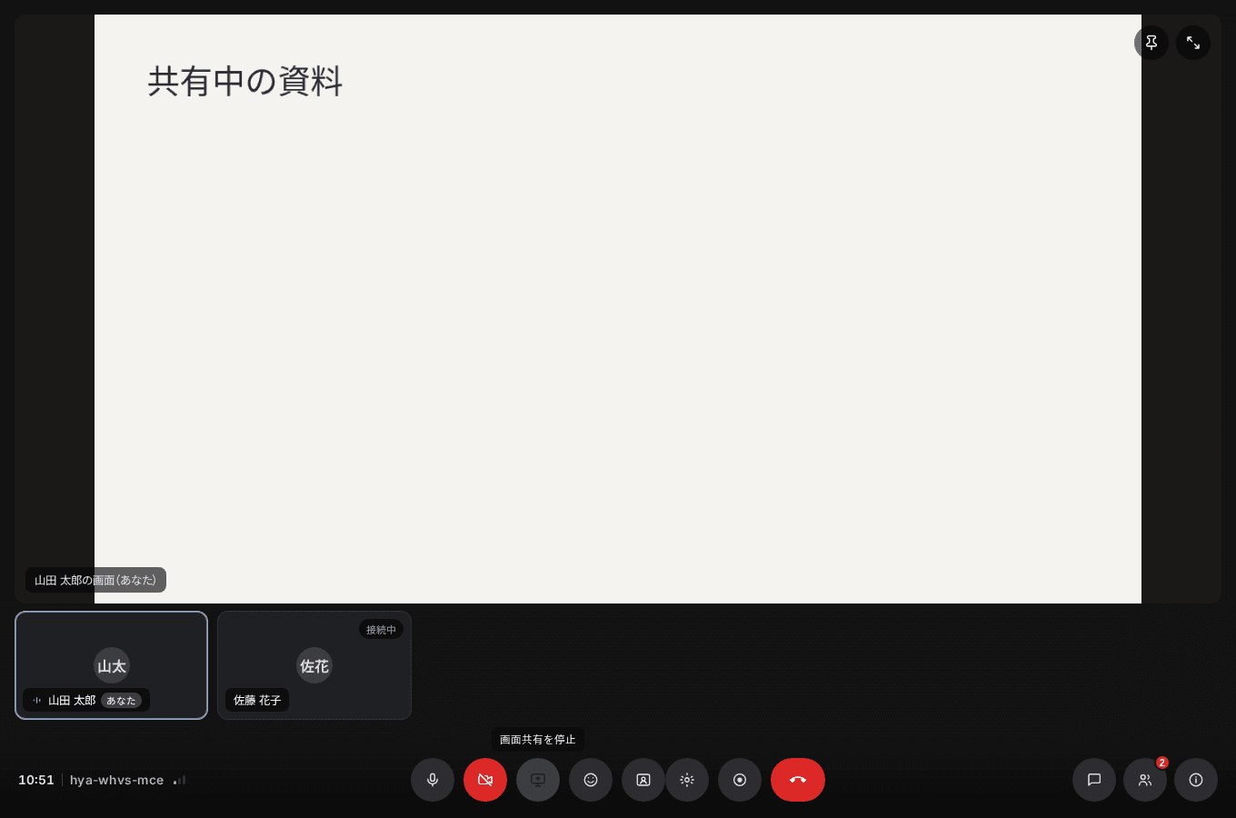 会議室で資料を画面共有している状態。共有画面が中央に大きく表示され、下部に画面共有を停止する操作がある。